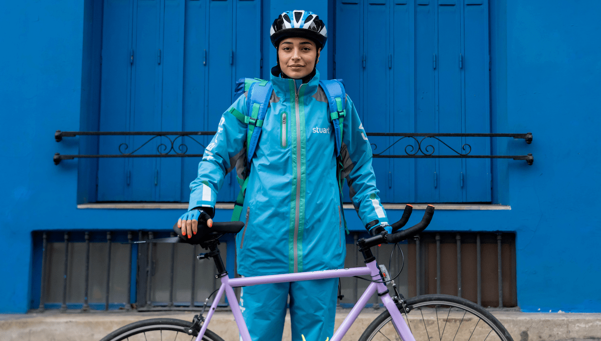 A woman courier standing with her bike