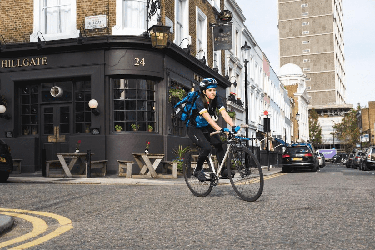 Courier cycling on a London street
